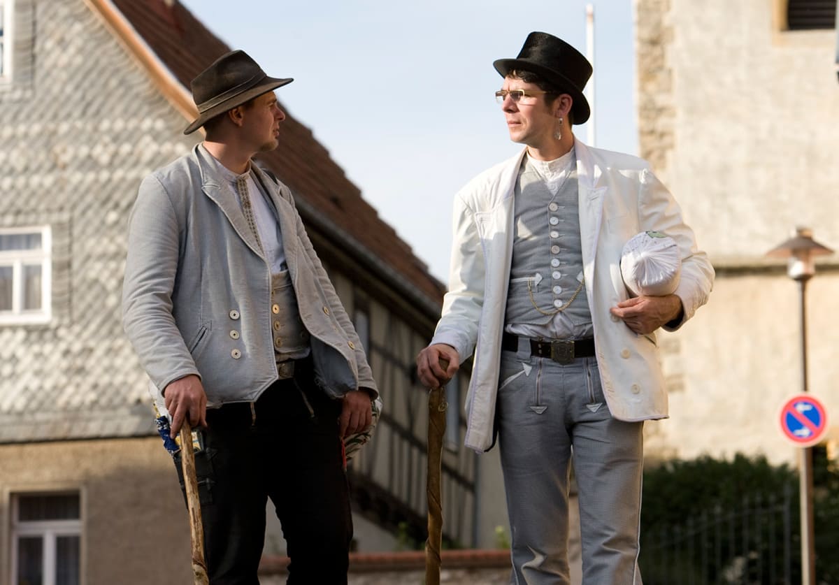 Zwei Bäckergesellen unterhalten sich gehend