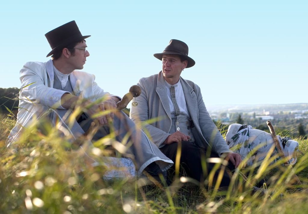 Zwei Bäckergesellen sitzen auf der Wiese